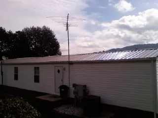 New metal roof on a single wide mobile home with a TV antenna in Pinecliffe
