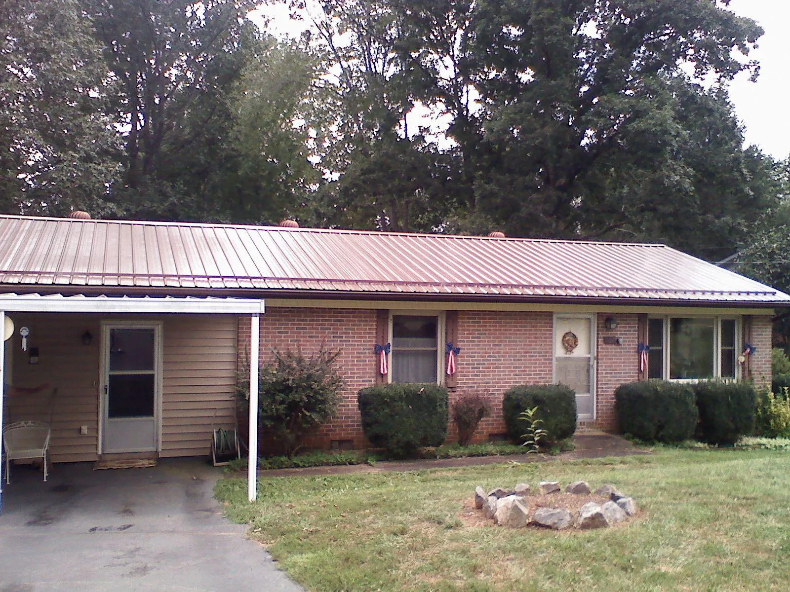 Bronze metal roof and carport on a brick ranch home — Roof Repair work by our crew in Pinecliffe